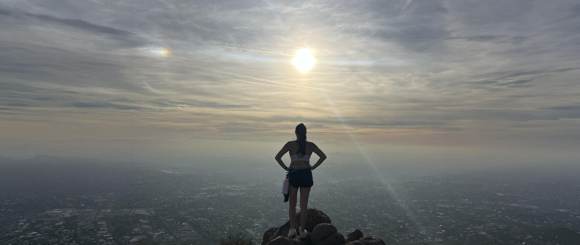 Sabrina Rodgers on a mountain overlook above the city at sunrise