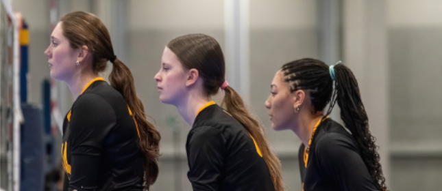 Three Rockets volleyball players together on court