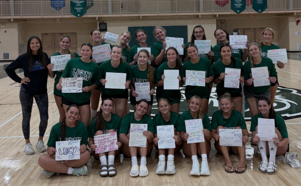 Sabrina with a volleyball team holding up handwritten posters